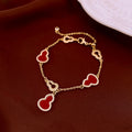 Gold bracelet with red hulu charms on a brown fabric background