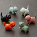 Set of colorful ceramic cat figurines on a dark surface