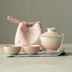 Tea set with glass teapot and ceramic cups on a neutral background